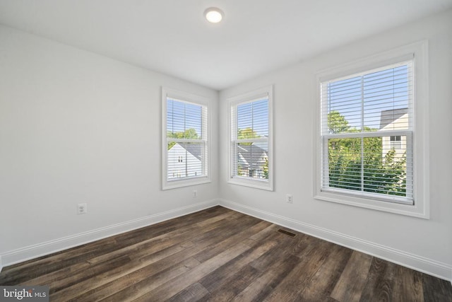 spare room with dark wood-style floors and baseboards