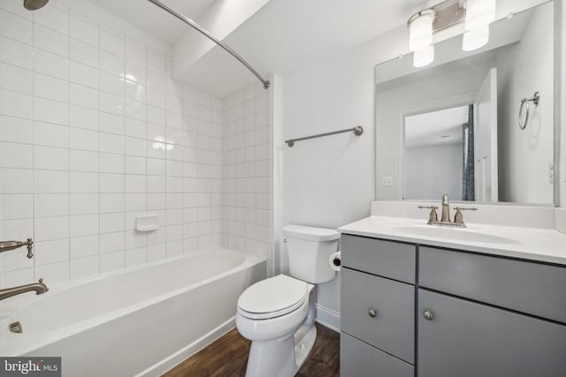 full bathroom with wood finished floors, toilet, vanity, bathtub / shower combination, and baseboards