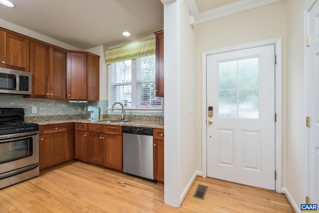 100 Melbourne Prk Cir Unit B, Charlottesville, VA 22901 - kitchen featuring stainless steel appliances, light wood-style flooring, light stone counters, crown molding, and brown cabinetry