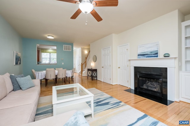 100 Melbourne Prk Cir Unit B, Charlottesville, VA 22901 - living room with wood finished floors, ceiling fan, a fireplace with flush hearth, and stairway