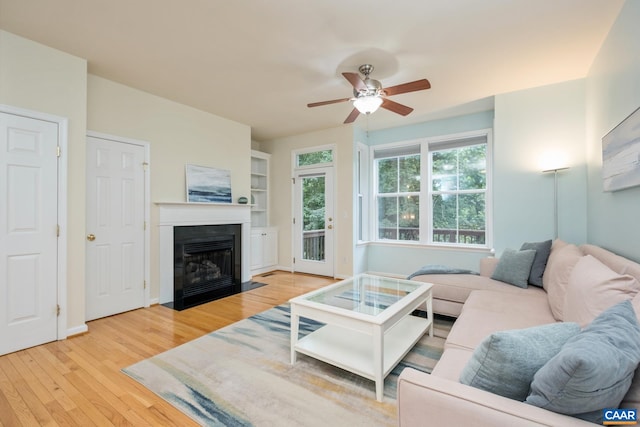 100 Melbourne Prk Cir Unit B, Charlottesville, VA 22901 - living area with light wood-style floors, ceiling fan, and a fireplace with flush hearth