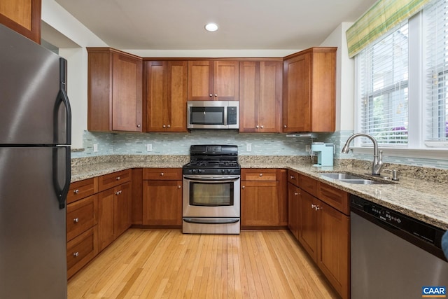 100 Melbourne Prk Cir Unit B, Charlottesville, VA 22901 - kitchen with appliances with stainless steel finishes, light wood-style floors, brown cabinets, light stone countertops, and recessed lighting