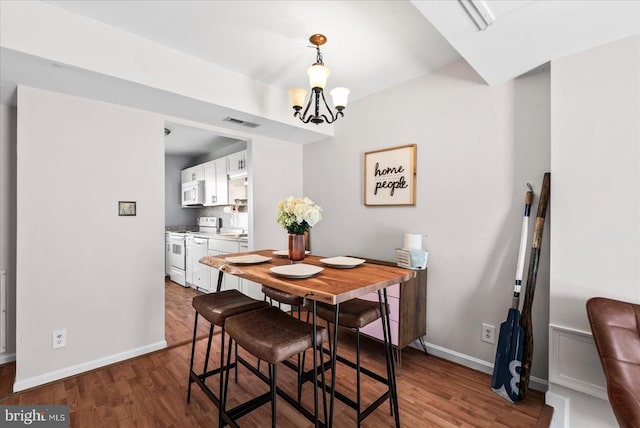 2211 Rock Creek Rd, Fredericksburg, VA 22407 - dining space featuring wood finished floors, a chandelier, and baseboards