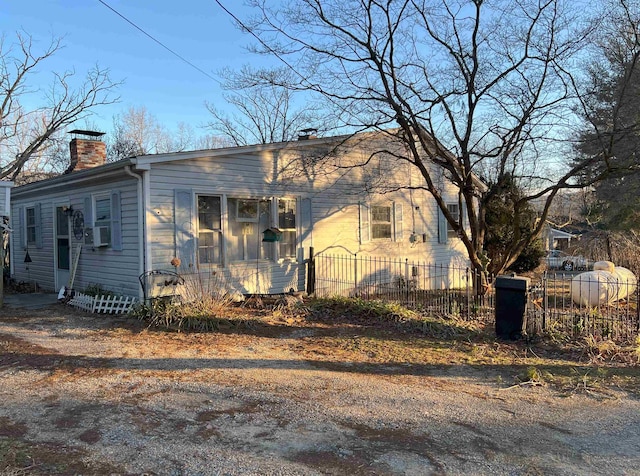 view of front of property featuring cooling unit, fence, and a chimney