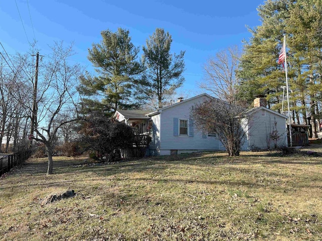 view of side of home with a yard