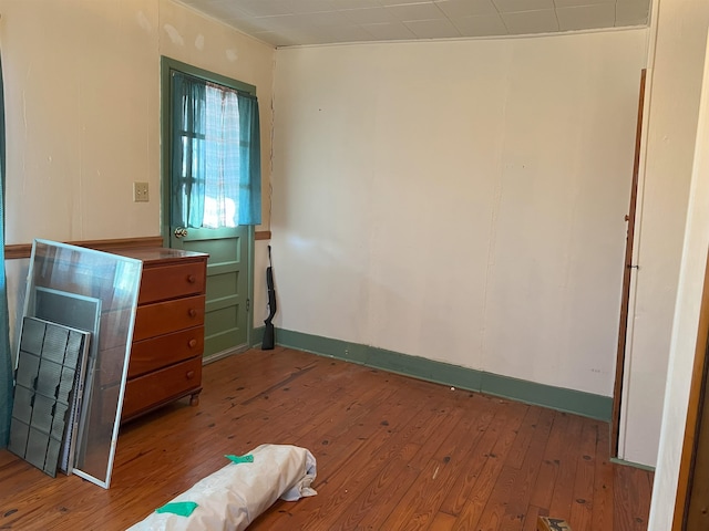 bedroom with wood-type flooring and baseboards