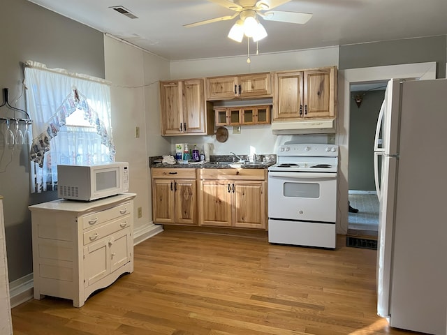 kitchen with light wood-type flooring, white appliances, under cabinet range hood, and visible vents