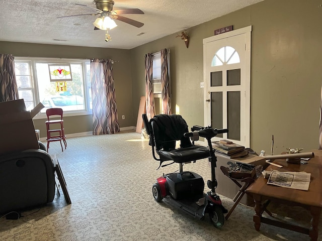 office space with ceiling fan, baseboards, and a textured ceiling