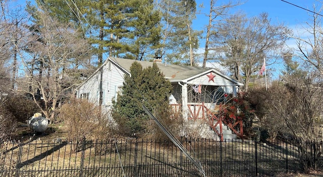 view of home's exterior with a chimney and fence