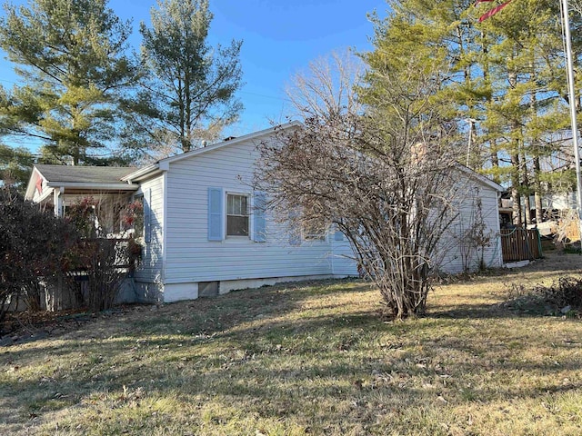 view of side of property with fence and a yard