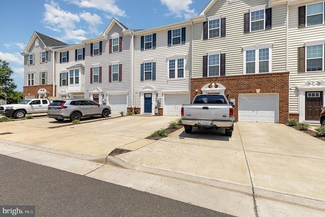  - colonial inspired home with brick siding, driveway, and a garage