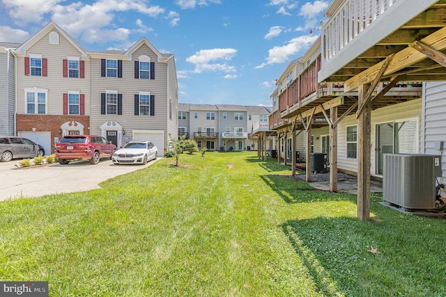  - view of grassy yard featuring driveway, a garage, and a residential view