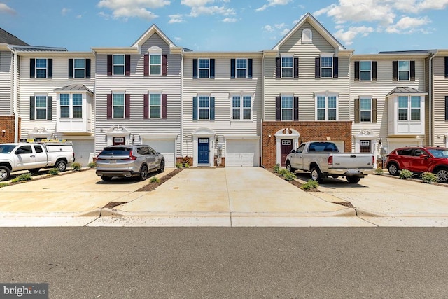  - colonial house with driveway, a garage, and brick siding