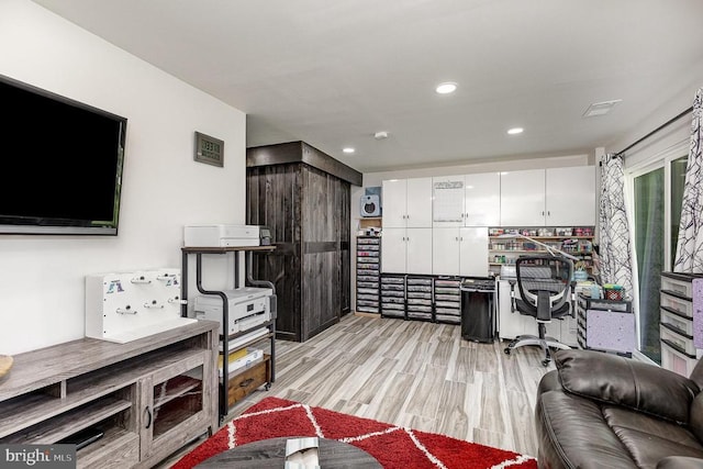  - office with light wood finished floors and recessed lighting