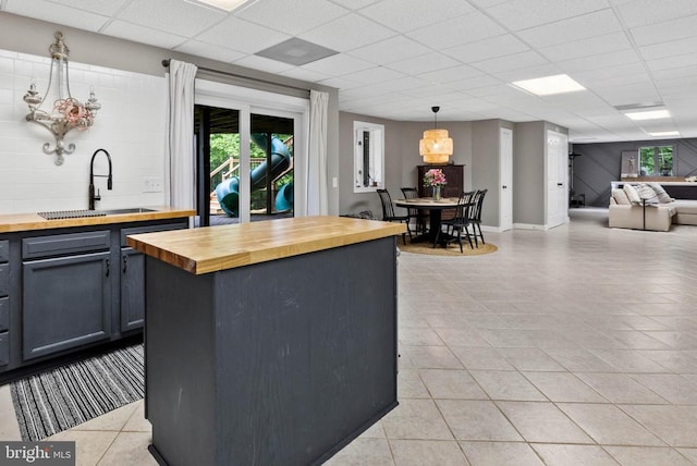 325 Oneals Rd, Madison, VA 22727 - kitchen with butcher block counters, a sink, a paneled ceiling, light tile patterned floors, and pendant lighting