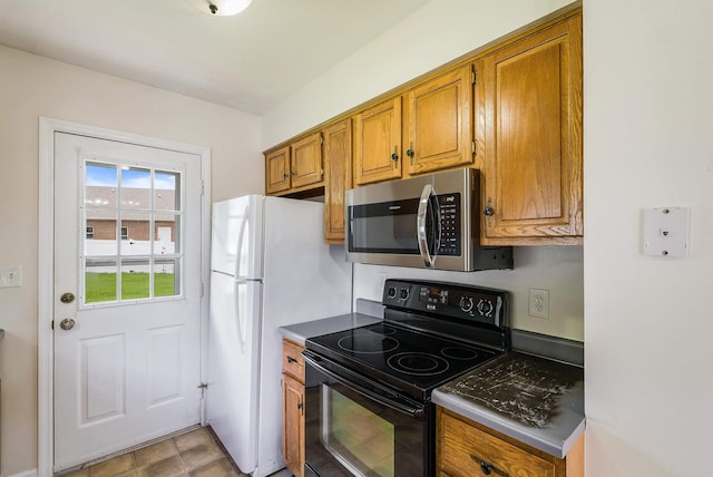 2090 Annandale Ct, Rockingham, VA 22801 - kitchen with stainless steel microwave, electric range, brown cabinetry, and dark countertops