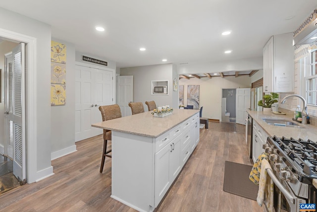 330 Carrsbrook Dr, Charlottesville, VA 22901 - kitchen with a sink, a breakfast bar, white cabinets, baseboards, and a center island