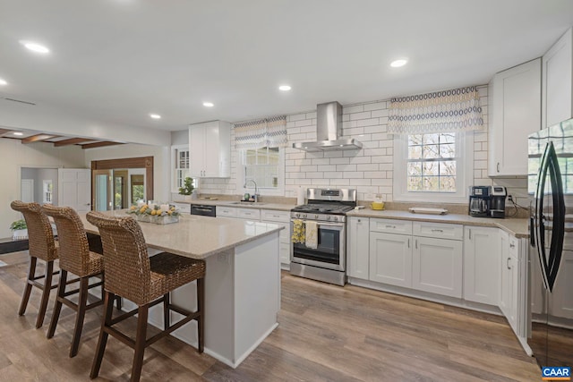 330 Carrsbrook Dr, Charlottesville, VA 22901 - kitchen featuring wall chimney range hood, stainless steel appliances, a sink, backsplash, and a breakfast bar