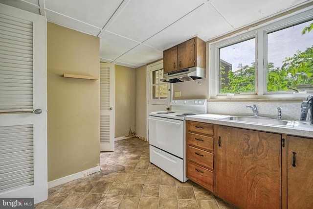 102 Washington St E, Remington, VA 22734 - kitchen with electric range, under cabinet range hood, a sink, light countertops, and brown cabinetry