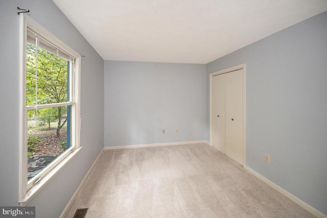 carpeted empty room with baseboards and visible vents