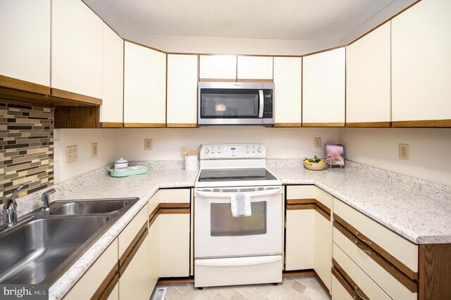 kitchen featuring stainless steel microwave, a sink, white cabinetry, light countertops, and white electric stove