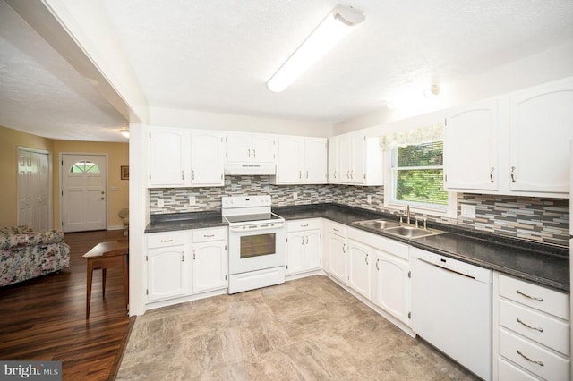 1406 Lakeview Pkwy, Locust Grove, VA 22508 - kitchen with white appliances, under cabinet range hood, dark countertops, white cabinets, and tasteful backsplash