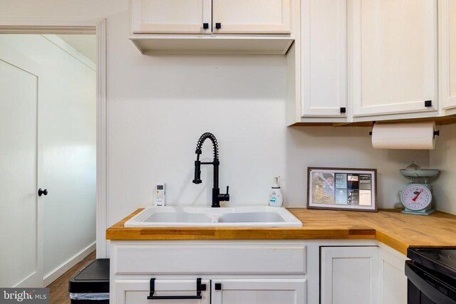 1246 Whispering Hill Rd, Luray, VA 22835 - kitchen with butcher block counters, a sink, white cabinetry, and wood finished floors