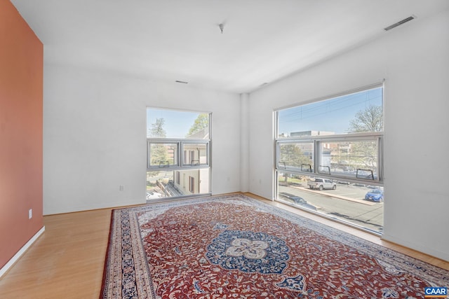 interior space with baseboards, visible vents, and wood finished floors