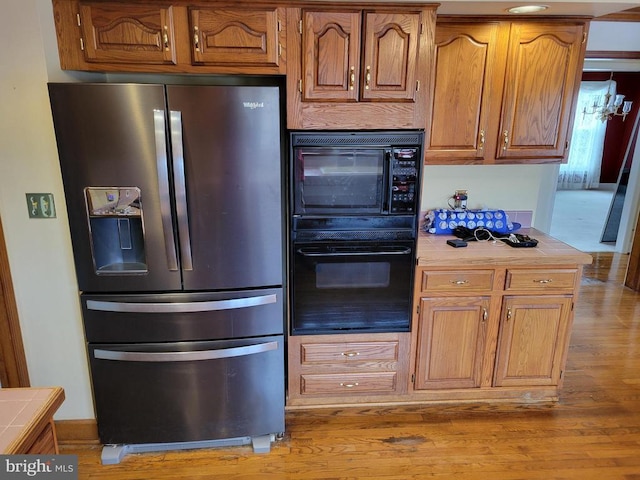 8408 Hildy Ct W, Spotsylvania, VA 22553 - kitchen with stainless steel fridge, tile counters, wood finished floors, and brown cabinets