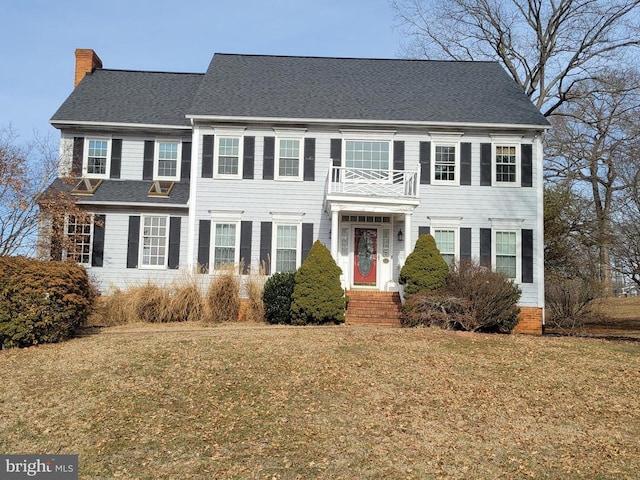8408 Hildy Ct W, Spotsylvania, VA 22553 - view of front of home featuring a chimney, a front lawn, a shingled roof, and a balcony
