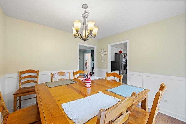 701 Horseshoe Cir, Stuarts Draft, VA 24477 - dining space with a chandelier, a wainscoted wall, wood finished floors, and a decorative wall