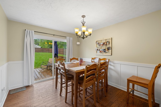701 Horseshoe Cir, Stuarts Draft, VA 24477 - dining room featuring a chandelier, wainscoting, hardwood / wood-style flooring, a textured ceiling, and a decorative wall