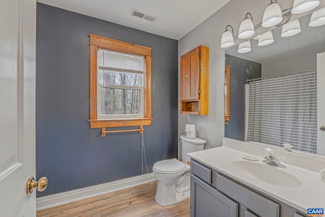 full bathroom featuring wood finished floors, baseboards, toilet, a shower with shower curtain, and vanity
