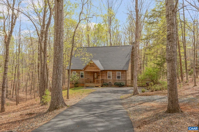 view of front facade with asphalt driveway and roof with shingles