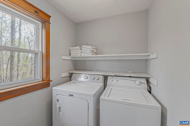 washroom with independent washer and dryer and a textured ceiling