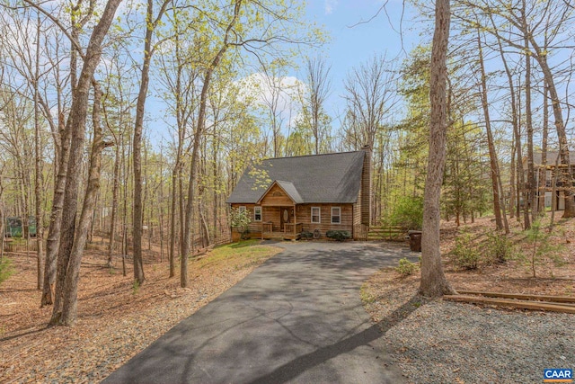 log home featuring driveway, a porch, and log exterior
