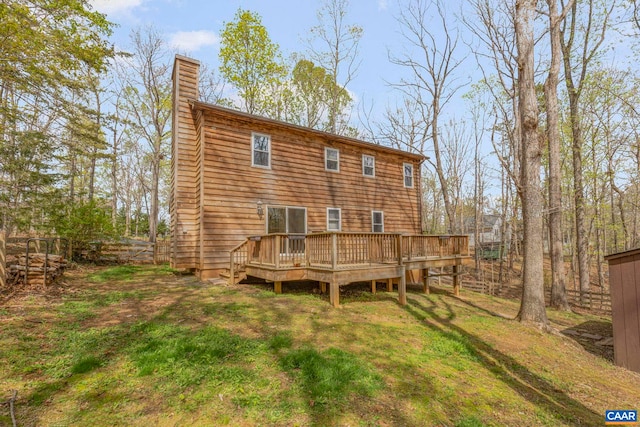 back of house featuring a chimney and a wooden deck