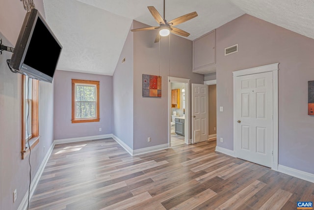 unfurnished living room featuring a ceiling fan, light wood-type flooring, high vaulted ceiling, and baseboards