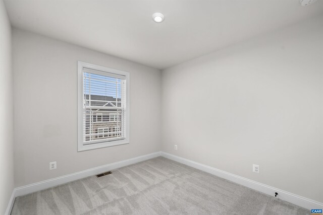 carpeted spare room with baseboards