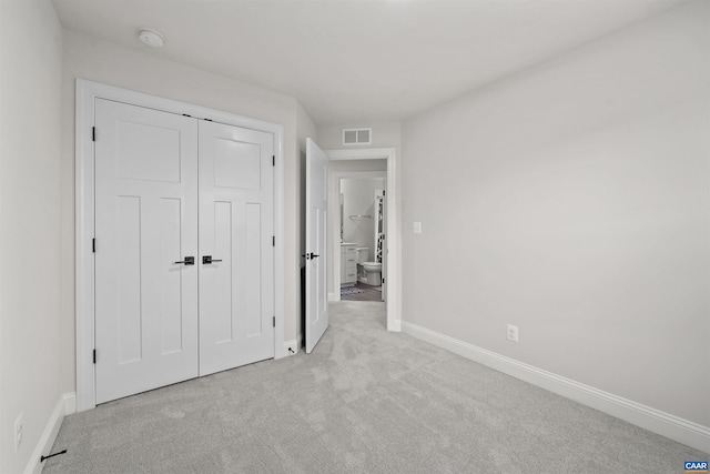 unfurnished bedroom featuring carpet floors, baseboards, and a closet