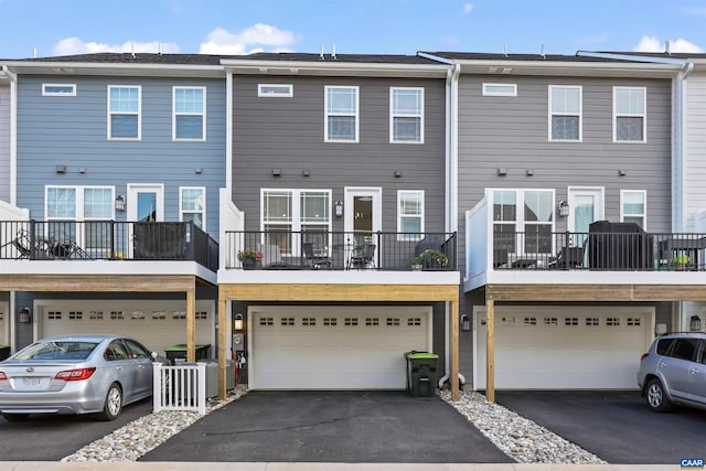 rear view of property featuring an attached garage and driveway