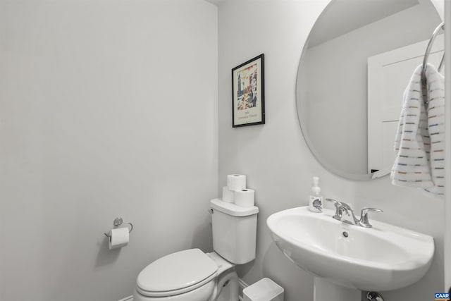 bathroom featuring a sink, toilet, and baseboards
