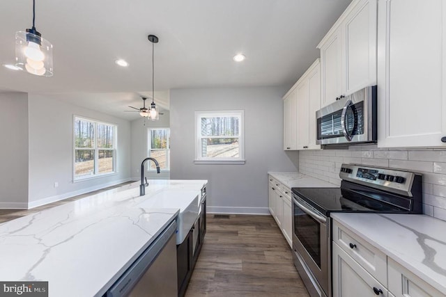 kitchen with stainless steel appliances, dark wood-style flooring, baseboards, white cabinets, and recessed lighting