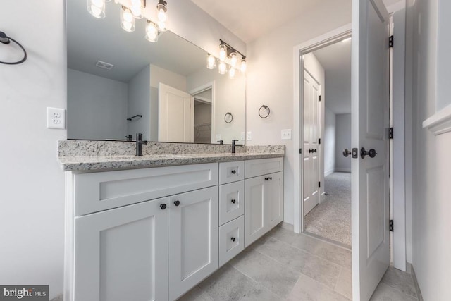 bathroom featuring double vanity and baseboards