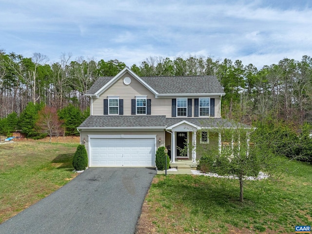 traditional home with an attached garage, a shingled roof, driveway, and a front yard
