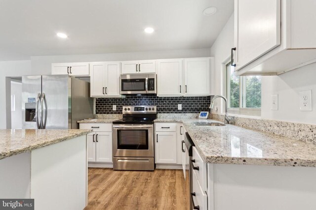92 Aspen Hill Rd, Mineral, VA 23117 - kitchen featuring appliances with stainless steel finishes, a sink, white cabinets, light wood-style flooring, and light stone counters