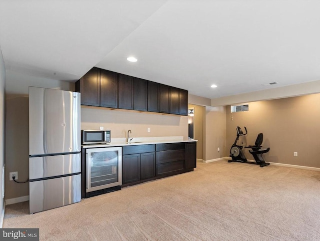 5505 Spring Bluff Ct, Fredericksburg, VA 22407 - kitchen with wine cooler, appliances with stainless steel finishes, light colored carpet, a sink, and light countertops