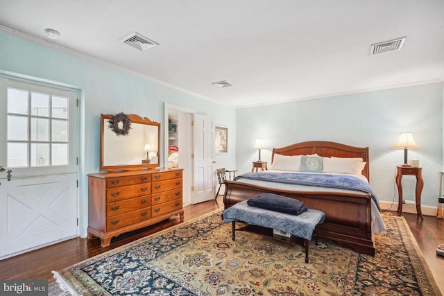 bedroom with ornamental molding, wood finished floors, and baseboards