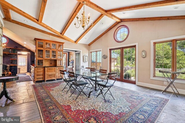 dining space featuring stone tile floors, high vaulted ceiling, beamed ceiling, a chandelier, and baseboards