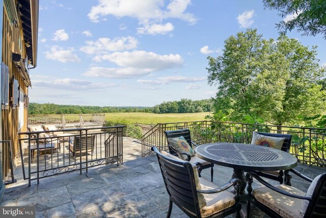 view of patio / terrace featuring a view of countryside and outdoor dining area